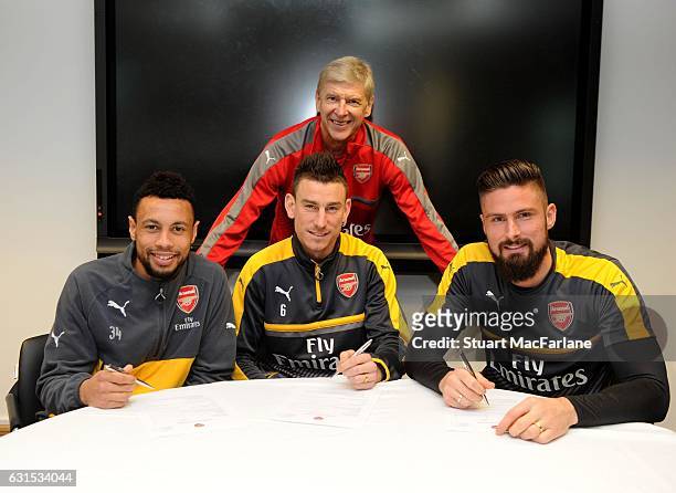 Arsenal's Francis Coquelin, Laurent Koscielny and Olivier Giroud sign their new contracts with manager Arsene Wenger at London Colney on January 5,...