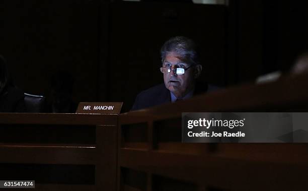 Sen. Joe Manchin is lit by his cell phone after the lights went out during Mr. Pompeo's confirmation hearing to be the director of the CIA before the...