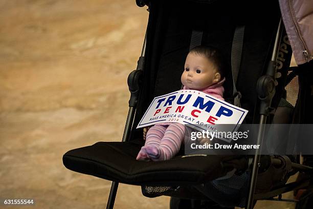 Baby doll in a stroller with a 'Trump/Pence' bumper sticker is pushed through the lobby at Trump Tower, January 12, 2017 in New York City....