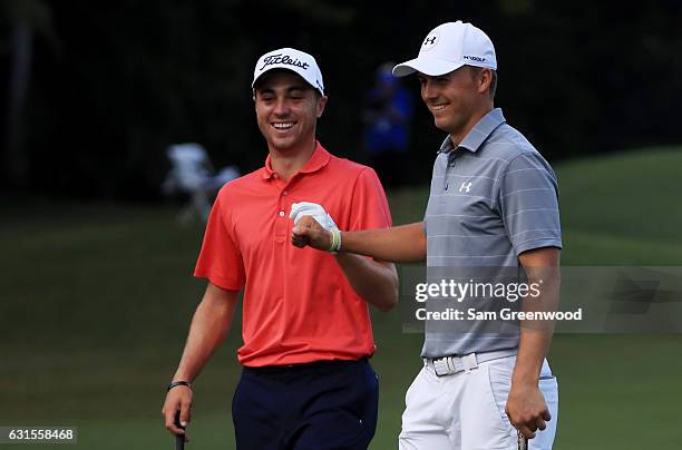 Justin Thomas of the United States is congratulated by Jordan Spieth of the United States after chipping in on the tenth hole during the first round...