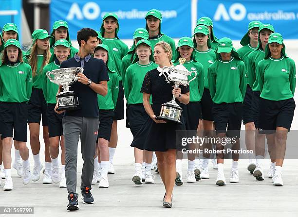 Defending champions Novak Djokovic of Serbia and Angelique Kerber of Germany carry the Australian Open trophies prior to the official draw ahead of...