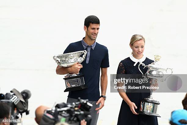 Defending champions Novak Djokovic of Serbia and Angelique Kerber of Germany carry the Australian Open trophies prior to the official draw ahead of...