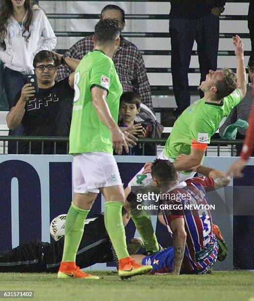 Brazilian defender Tiago of EC Bahia tackles Julian Klamt Gof of German club VFL Wolfsburg, in front of goal keeper Alexander Brunst during their...