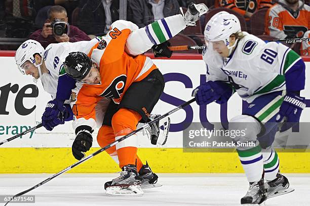 Matt Read of the Philadelphia Flyers bodychecks Jayson Megna of the Vancouver Canucks during the first period at Wells Fargo Center on January 12,...