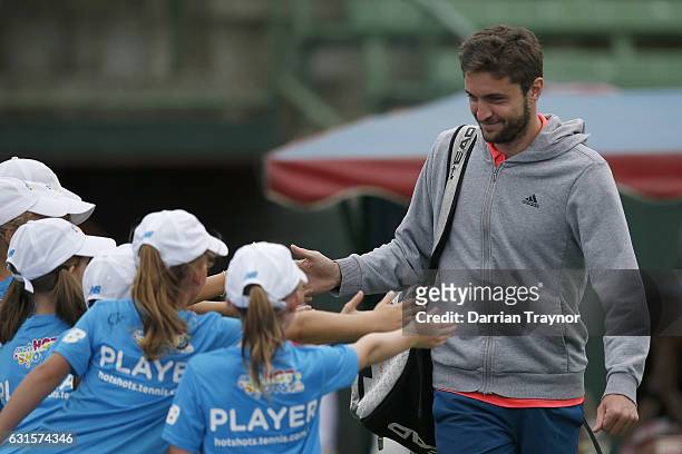 Gilles Simon of Francehigh fives the young tennis players before his match against Bernard Tomic of Australia during day four of the 2017 Priceline...