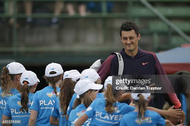 Bernard Tomic of Australia winks and high fives the young tennis players before his match against Gilles Simon of France during day four of the 2017...