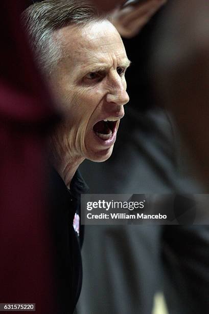 Head coach Mike Dunlap of the Loyola Marymount Lions huddles with his players during a timeout in the first half against the Gonzaga Bulldogs at...