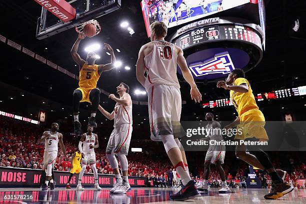 Obinna Oleka of the Arizona State Sun Devils slam dunks the bal over Dusan Ristic of the Arizona Wildcats during the second half of the college...