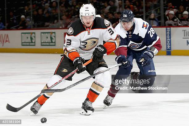 Jakob Silfverberg of the Anaheim Ducks fights for conntrol of the puck against Patrick Wiercioch the Colorado Avalanche at the Pepsi Center on...