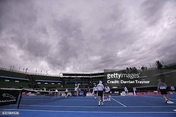 Ball boys and girls dry the court after heavy rain falls before the mens final between David Goffin of Belgium anf Ivo Karlovic of Croatia during day...