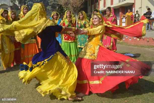 Young Indian students wear traditional Punjabi dress as they perform the 'Giddha' dance during celebrations on the occasion of the Lohri Festival in...