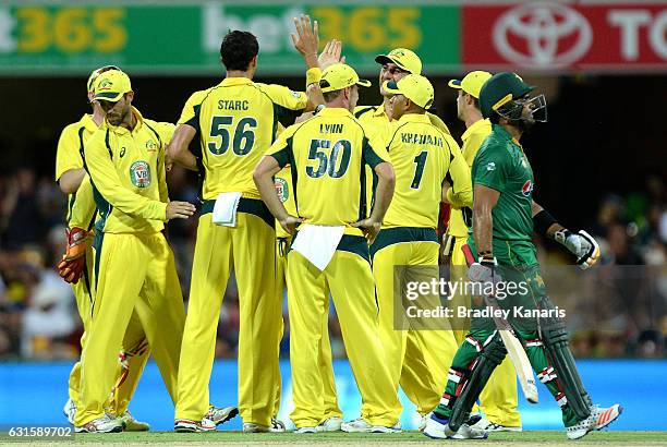 Umar Akmal of Pakistan looks dejected after losing his wicket as the Australian team celebrate during game one of the One Day International series...