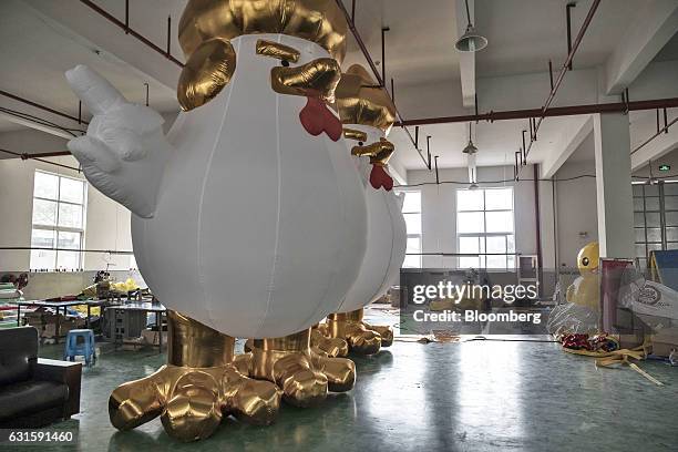 Inflatable chickens, bearing a likeness to U.S. President-elect Donald Trump and produced ahead of the Lunar New Year of the Rooster, stand at a...