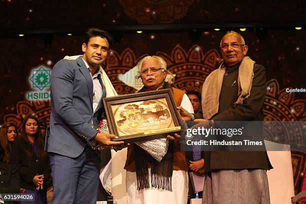 Indian wrestler Sangram Singh, Haryana CM Manohar Lal Khattar and Governor of Haryana Kaptan Singh Solanki during the first Pravasi Haryana Divas,...