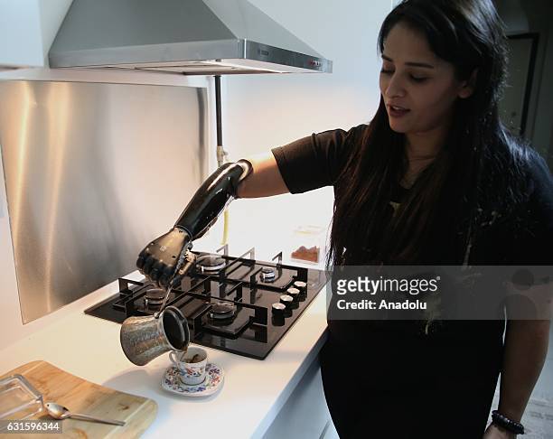 Amputee Zubeyde Nisa Karabacak, 26-years-old, pours Turkish coffee to a cup with her "bionic arm" named "Revo" during an exclusive interview at her...
