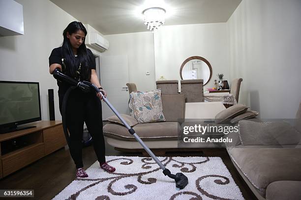 Amputee Zubeyde Nisa Karabacak, 26-years-old, vacuums a carpet with her "bionic arm" named "Revo" during an exclusive interview at her home in...