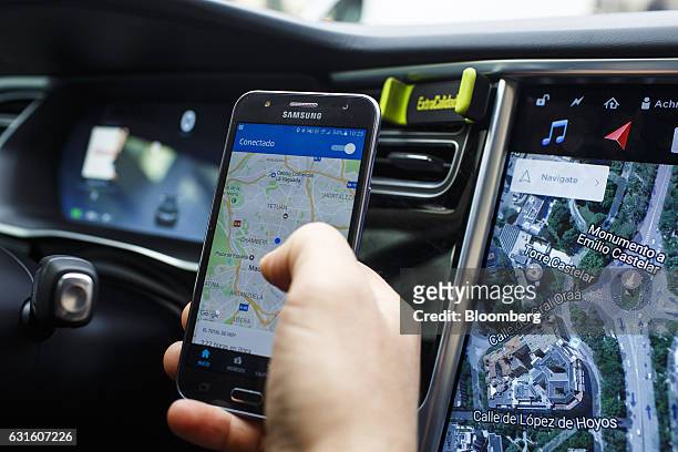 An Uber Technologies Inc. Driver uses the company's smartphone app in a Tesla Motors Inc. Model S electric automobile in Madrid, Spain, on Friday,...