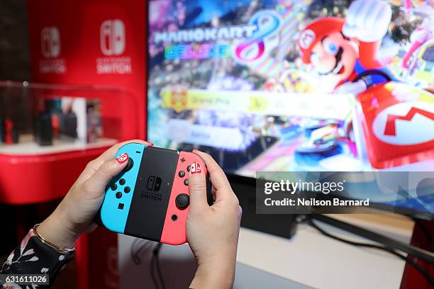 Nintendo of America, A guest enjoys playing Mario Kart 8 Deluxe on the groundbreaking new Nintendo Switch at a special preview event in New York on...