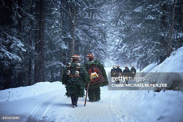 Members of a yodel group 'Schuppel' walk in the snow during the 'Silvesterchlausen' in the early morning in Urnaesch in the Swiss canton Appenzell...