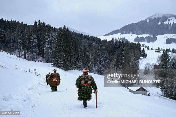 Members of a yodel group 'Schuppel' walk in the snow during the 'Silvesterchlausen' in the early morning in Urnaesch in the Swiss canton Appenzell...