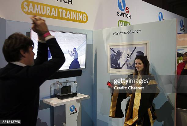 Attendees play the "Samourai training" video game with a Nintendo Switch games console during the new console's unveiling by Nintendo Co on January...