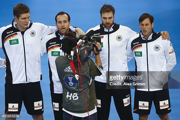 Camera man walks past Finn Lemke, Silvio Heinevetter, Andreas Wolff and Uwe Gensheimer of the German team during the national anthem prior to the...
