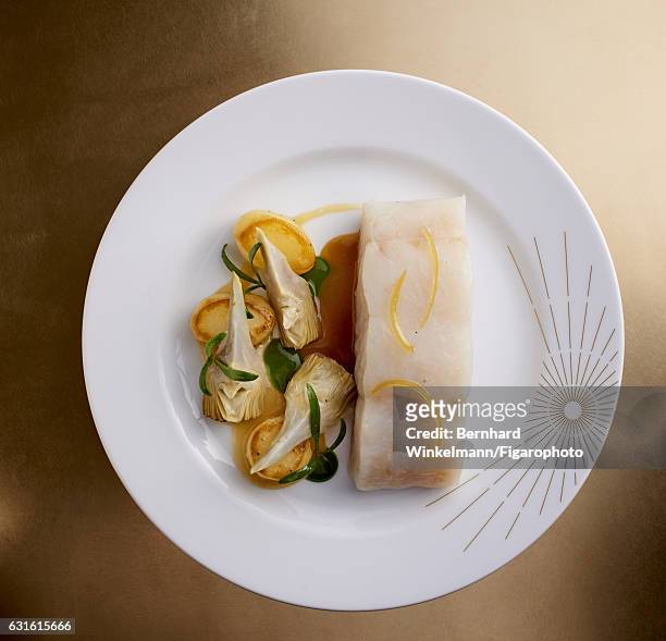 Yellow pollock, artichokes and potatoes are photographed for Madame Figaro on November 25, 2016 in Versailles, France. From Alain Ducasse's Ore, the...