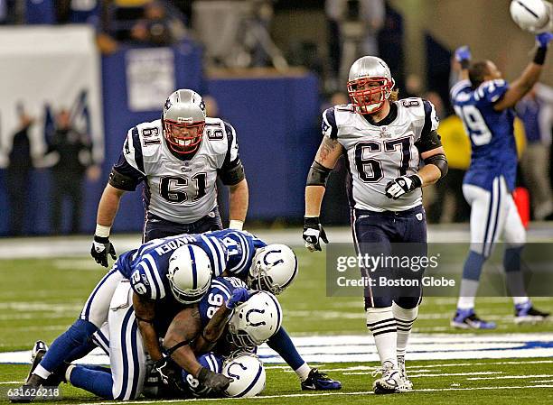 Patriots' Stephen Neal and Dan Koppen can only look on as Colt's Marlin Jackson is mobbed by his teammates after he picked off Tom Brady's pass to...