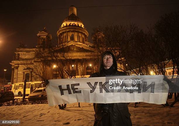Protester holds a banner during a demonstration to protest against the transfer the St. Isaac's Cathedral in St Petersburg, Russia to the Russian...