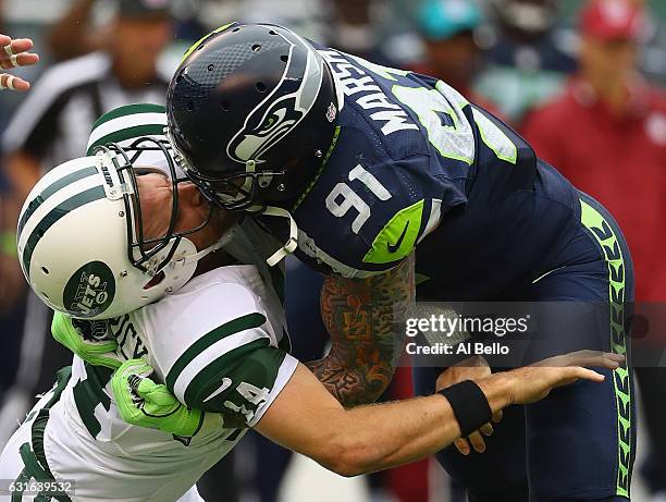 Cassius Marsh of the Seattle Seahawks hits his helmet against quarterback Ryan Fitzpatrick of the New York Jets for a penalty 'Roughing the Passer'...