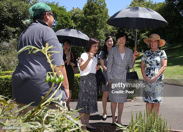 Akie Abe, second right, wife of Japanese Prime Minister Shinzo Abe holds an umbrella for herself and Lucy Turnbull, right, wife of Australian Prime...