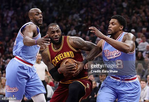 LeBron James of the Cleveland Cavaliers dribbles between Rudy Gay and Anthony Tolliver of the Sacramento Kings at Golden 1 Center on January 13, 2017...