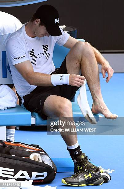 Andy Murray of Great Britain puts his sock on fter receiving treatment to an injured toe during a practice session ahead of the Australian Open...