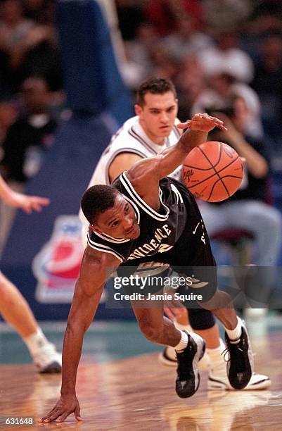 John Linehan of the Providence Friars slips on the court with the ball during the Big Ten Conference game against the Pennsylvania State Nittany...