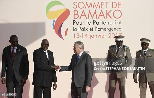 Malian Foreign Affairs Minister Abdoulaye Diop looks over as Malian Prime Minister Modibo Keita greets French Minister of Foreign Affairs Jean-Marc...