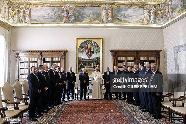 Palestinian president Mahmud Abbas poses with Pope Francis and delegates, during a private audience at the Vatican on January 14, 2017. Abbas meets...