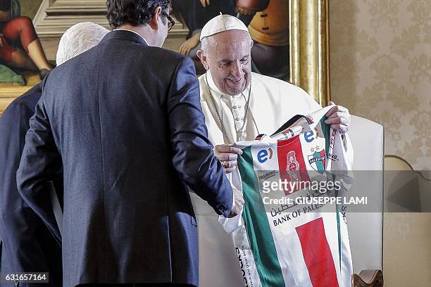 Pope Francis receives a palestinian football shirt, during a private audience with Palestinian president Mahmud Abbasat the Vatican on January 14,...