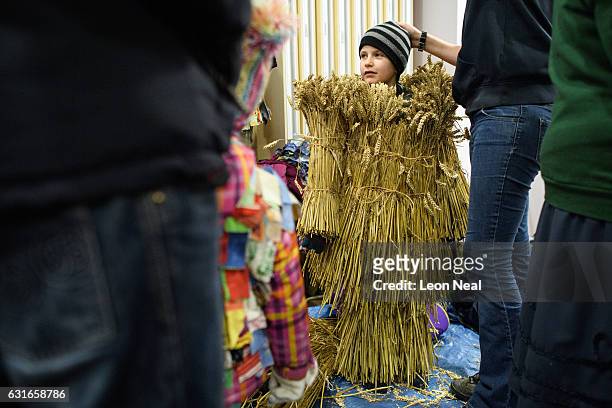Noah Randall is helped into his child's Straw Bear costume before the annual Whittlesea Straw Bear Festival parade on January 14, 2017 in Whittlesey,...