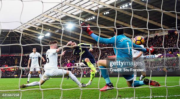 Olivier Giroud strokes in the first Arsenal goal past Lukasz Fabianski during the Premier League match between Swansea City and Arsenal at Liberty...