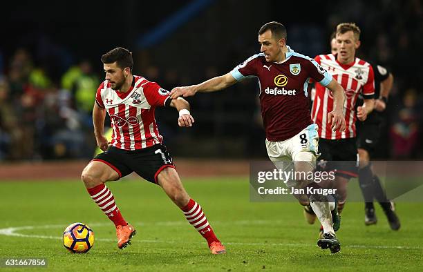 Shane Long of Southampton is held back by Dean Marney of Burnley during the Premier League match between Burnley and Southampton at Turf Moor on...