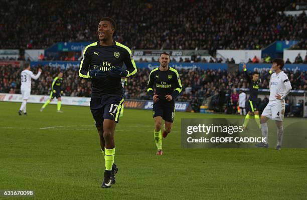 Arsenal's Nigerian striker Alex Iwobi celebrates his team's second goal after his shot was defelected into goal off Swansea City's English midfielder...