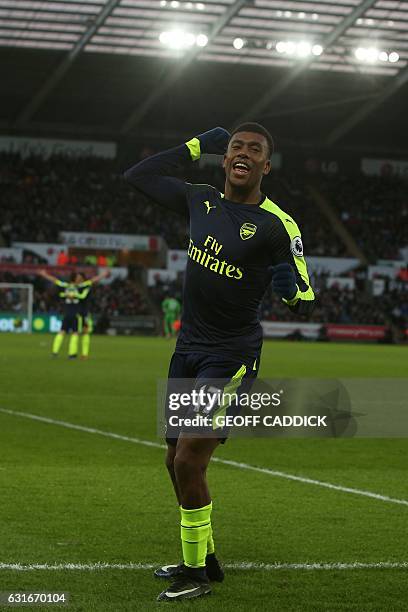 Arsenal's Nigerian striker Alex Iwobi celebrates his team's second goal after his shot was defelected into goal off Swansea City's English midfielder...