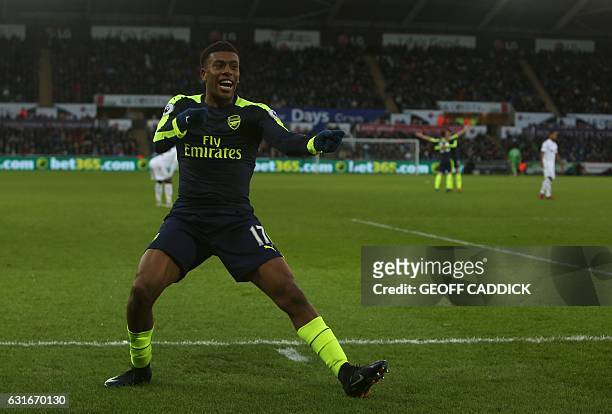 Arsenal's Nigerian striker Alex Iwobi celebrates his team's second goal after his shot was defelected into goal off Swansea City's English midfielder...