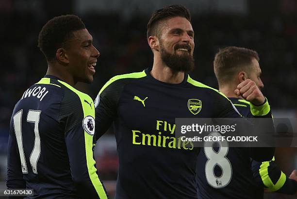 Arsenal's Nigerian striker Alex Iwobi celebrates his team's second goal with Arsenal's French striker Olivier Giroud , after his shot was defelected...