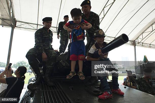 Thai children climb a military vehicle during the National Children's Day event inside a military base in Bangkok, Thailand, on 14 January 2017.