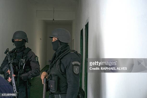 Special Operations Command personnel stand guard in a corridor connecting cells during a visit to the Anísio Jobim Penitentiary Complex --where 56...