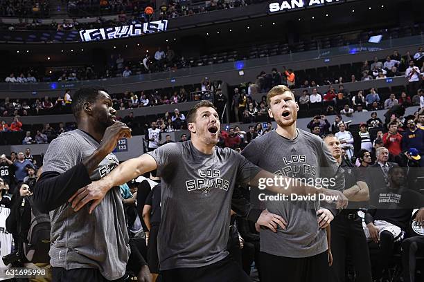 Dewayne Dedmon, David Lee and Davis Bertans of the San Antonio Spurs react to a play in warm ups before the game against the Phoenix Suns as part of...