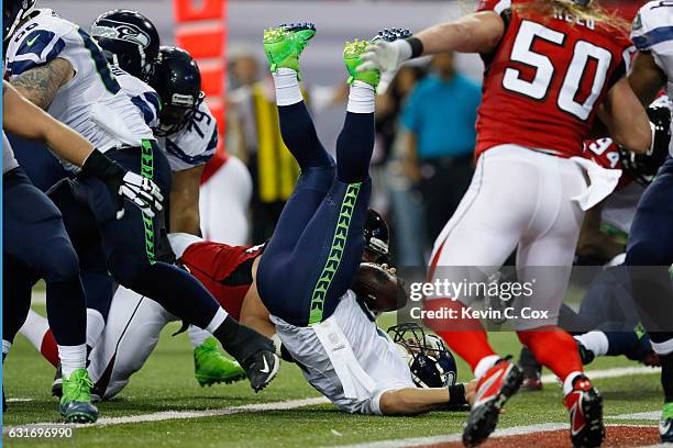 Russell Wilson of the Seattle Seahawks gets tackled for a safety against the Atlanta Falcons at the Georgia Dome on January 14, 2017 in Atlanta,...