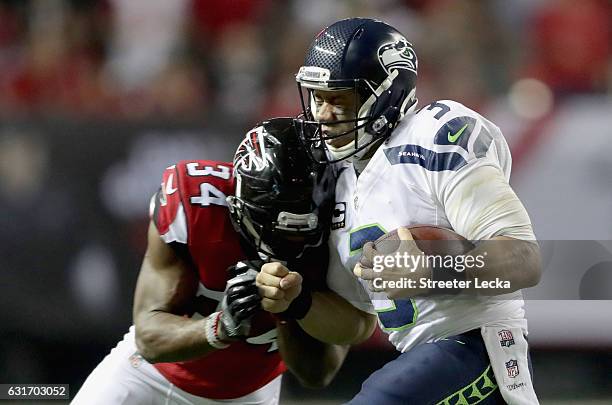 Brian Poole of the Atlanta Falcons hits Russell Wilson of the Seattle Seahawks during their game at the Georgia Dome on January 14, 2017 in Atlanta,...