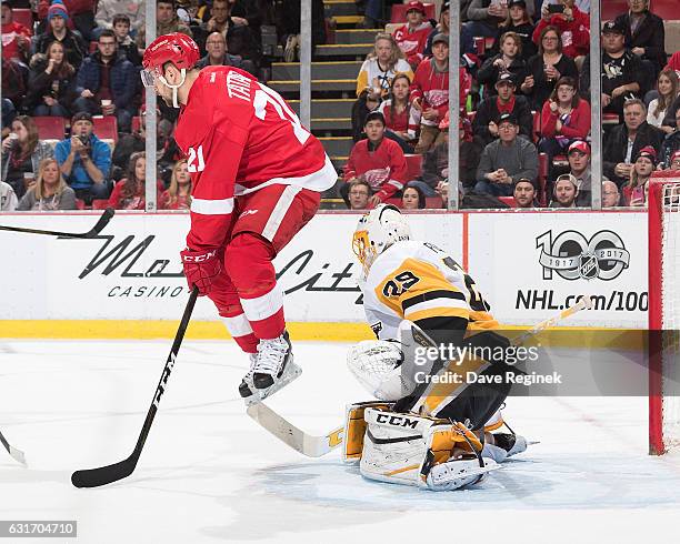 Tomas Tatar of the Detroit Red Wings jumps out of the way of a shot in front of goaltender Marc-Andre Fleury of the Pittsburgh Penguins during an NHL...